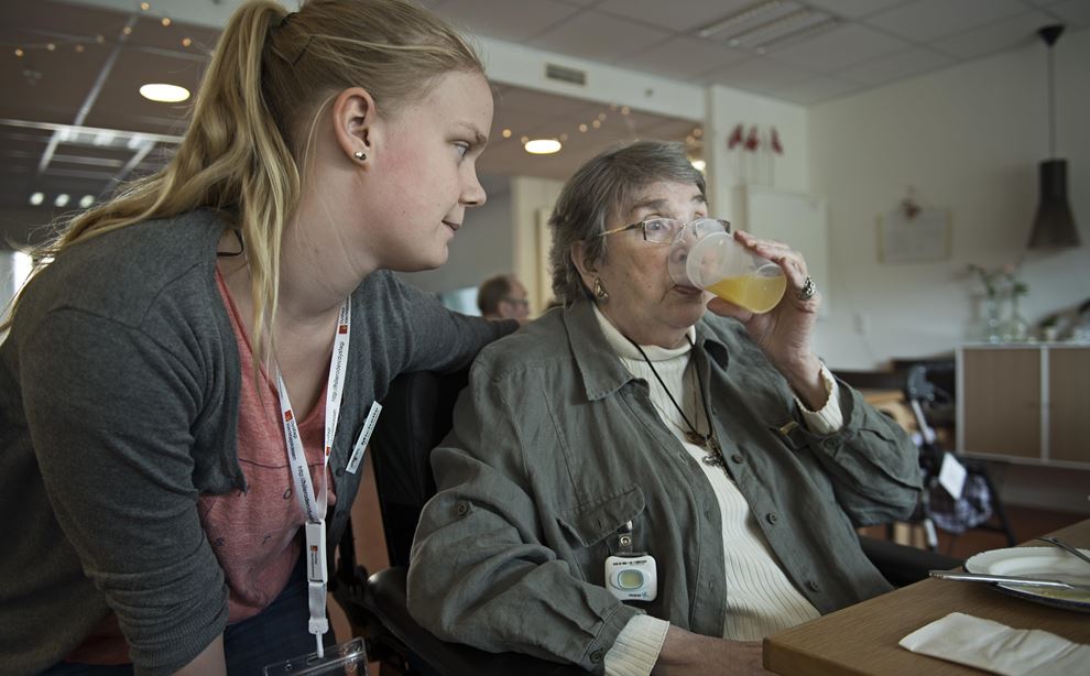 Fotografi af sosu-assistent, der hjælper ældre kvinde med at spise af fotograf Jørgen True
